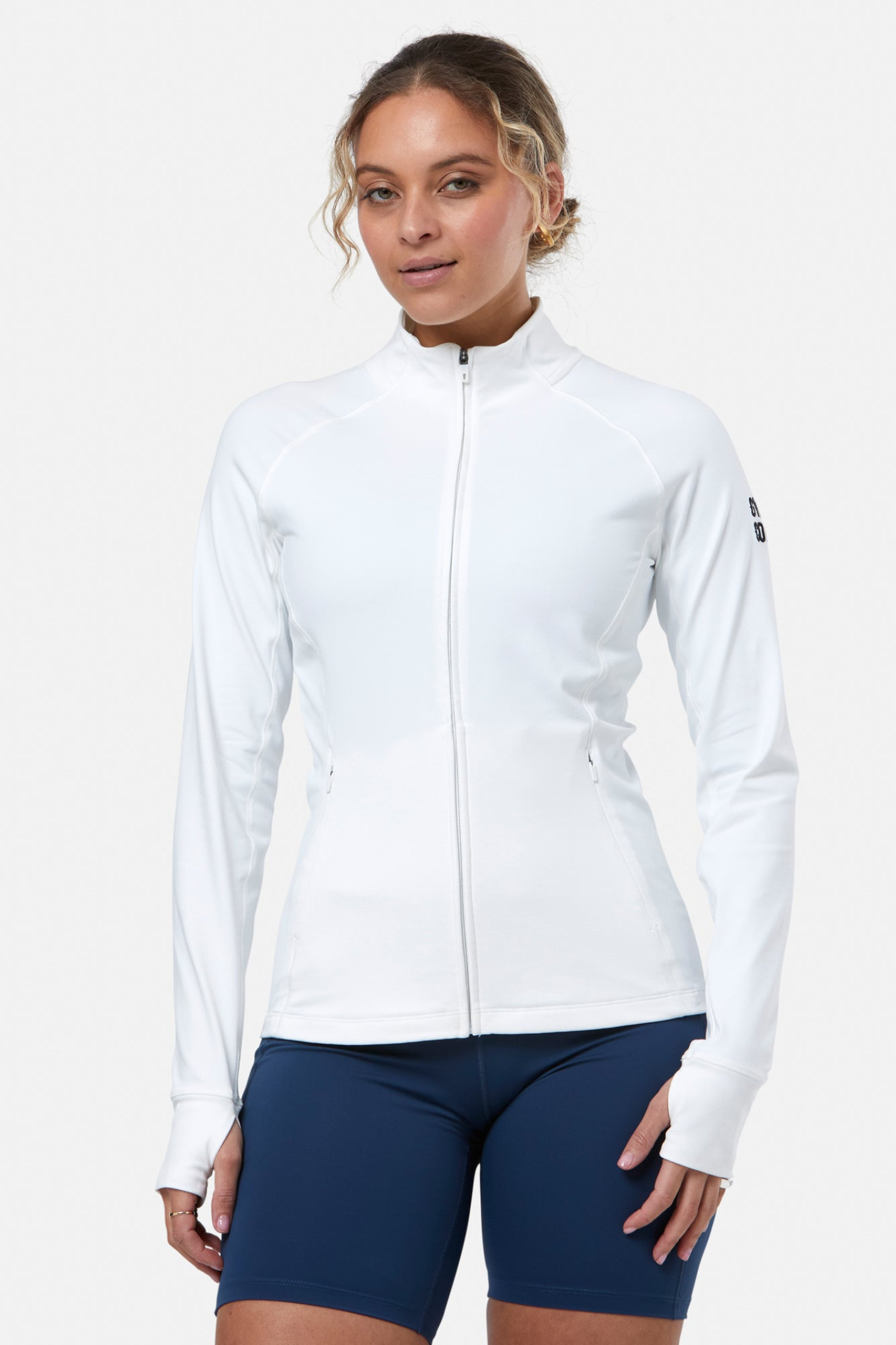 Woman wearing Gym+Coffee Relentless Full Zip Jacket in Ultra White by Gym+Coffee, shop Gym+Coffee at Dotique online.