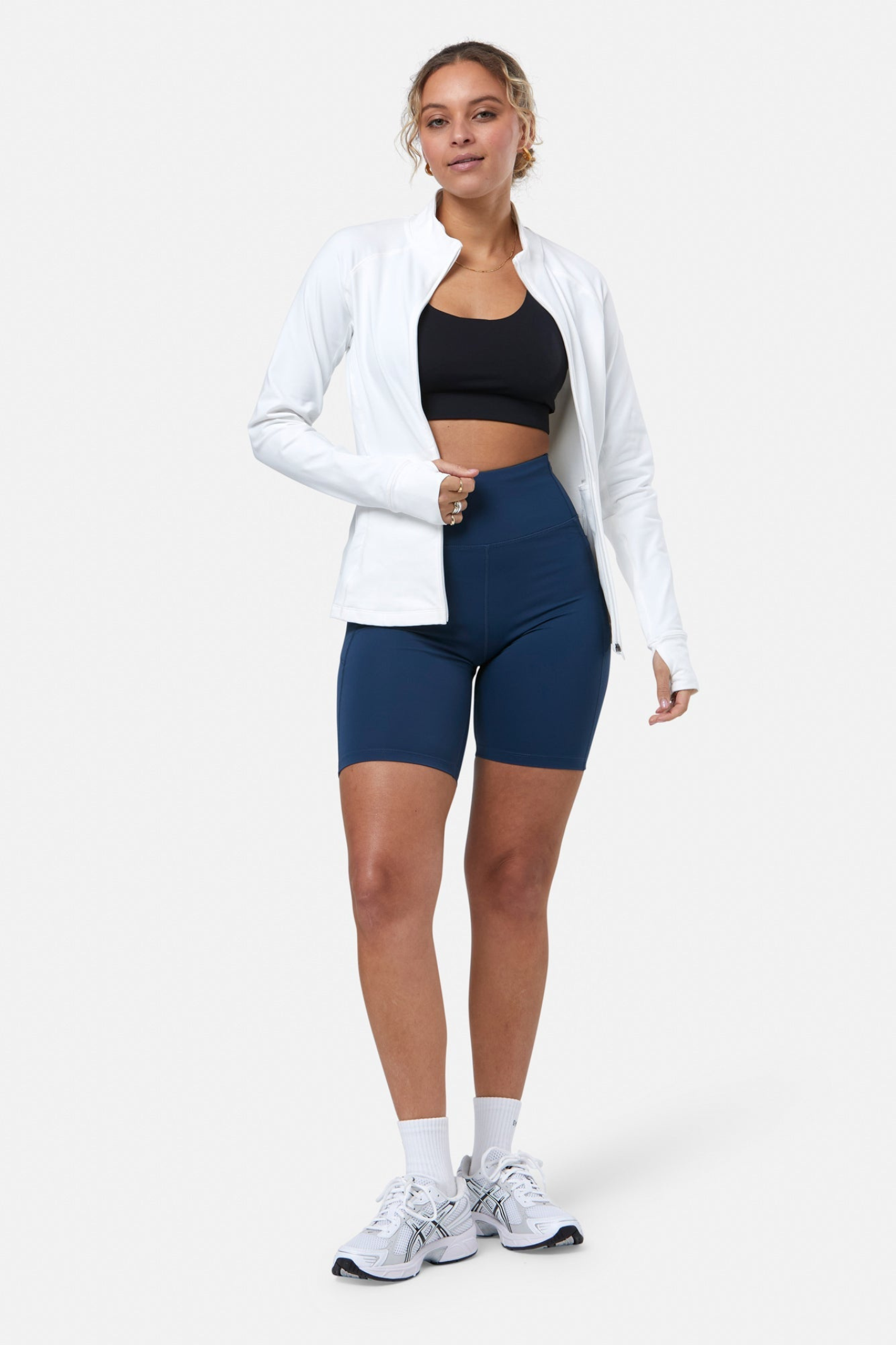 Woman wearing Gym+Coffee Relentless Full Zip Jacket in Ultra White by Gym+Coffee, shop the brand at Dotique online store