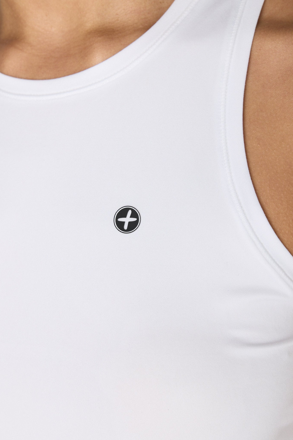 Close-up of a white Gym+Coffee Relentless Racer Back Vest Ultra White worn by a model, shop Gym+Coffee at Dotique