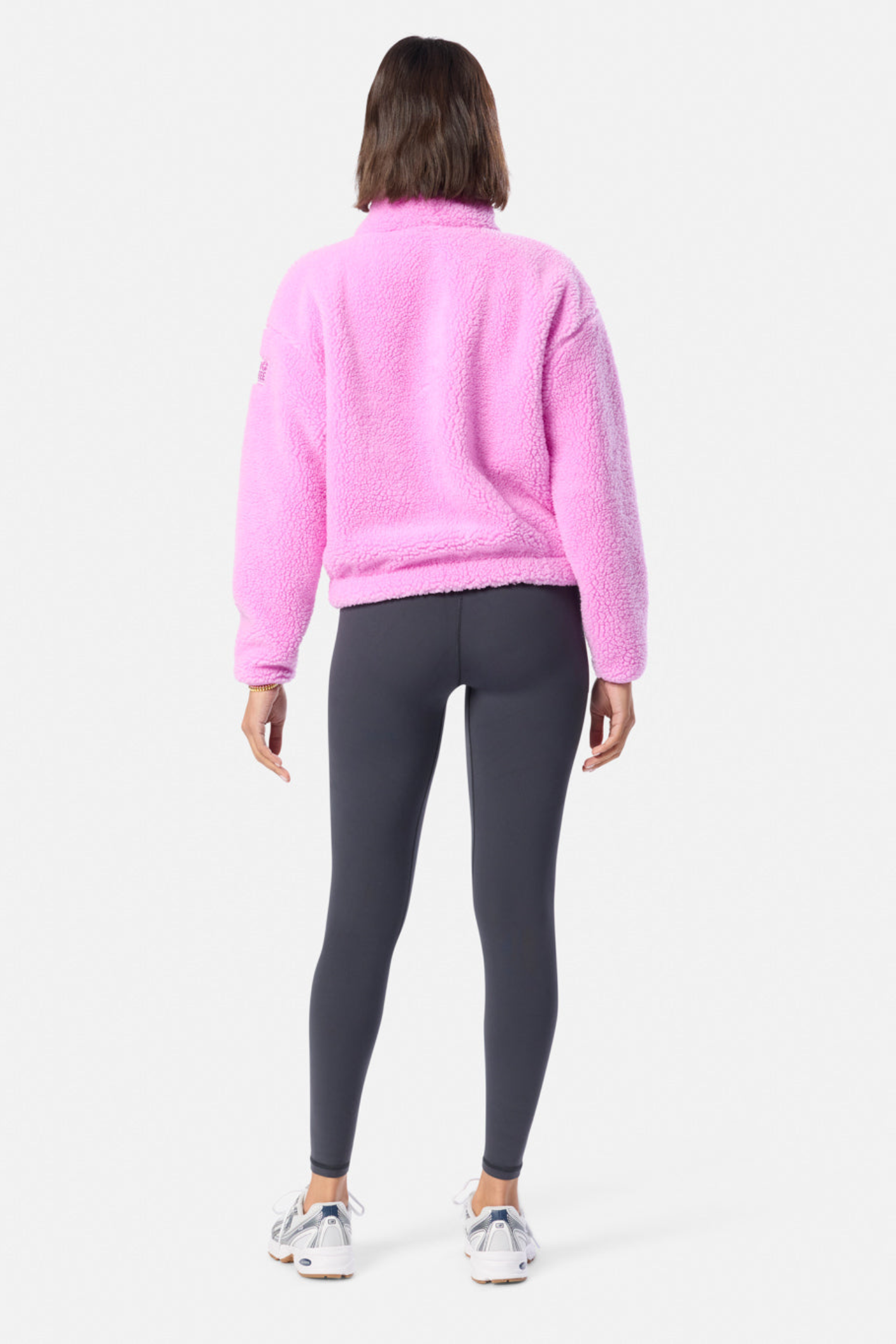 Back view of a model wearing Gym+Coffee Industry Fleece High Collar Jacket in Neon Pink by Gym+Coffee Shop at Dotique