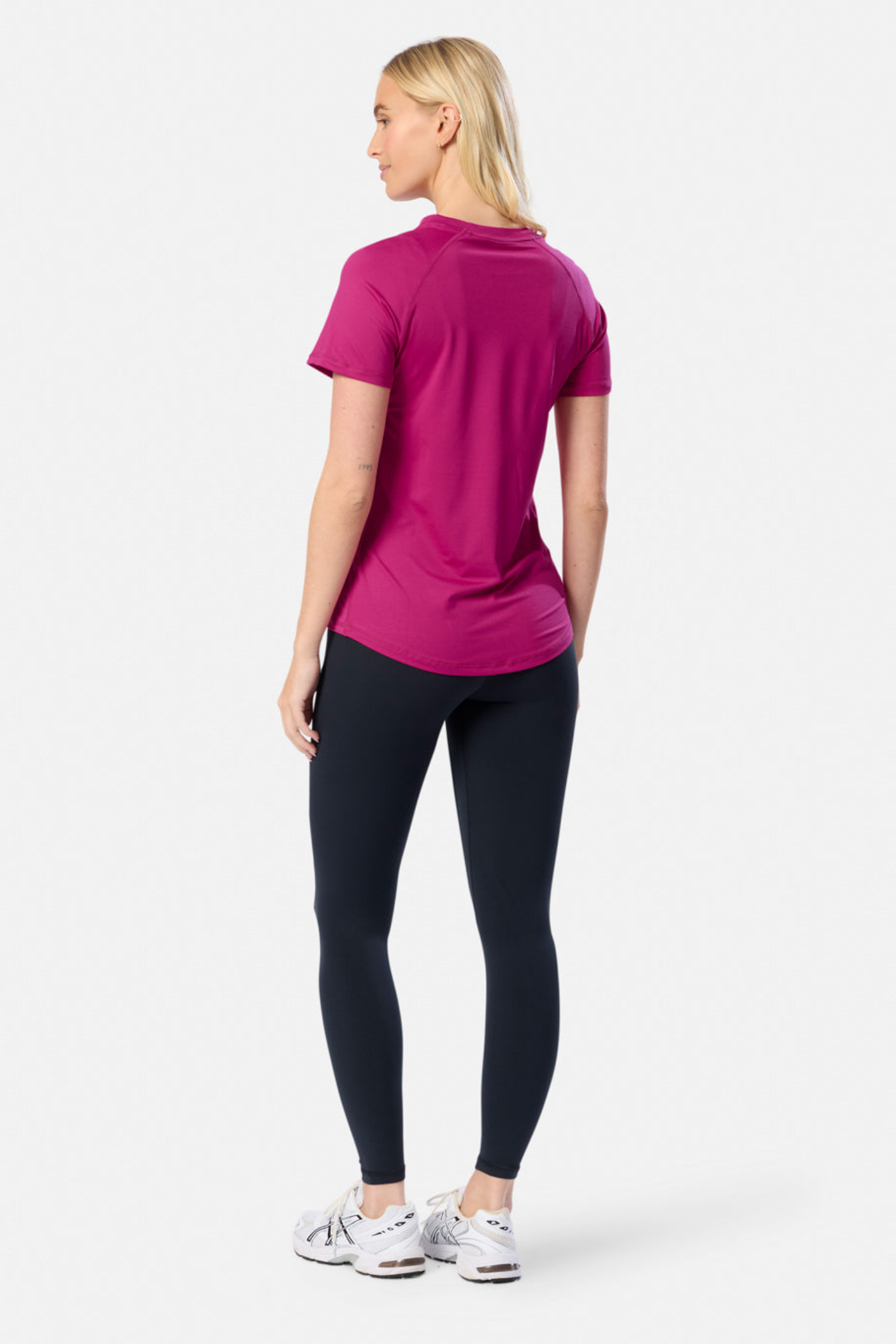 Back view of woman wearing Gym+Coffee Relentless Tee in Sunrise Pink by Gym+Coffee Shop the vendor at Dotique.