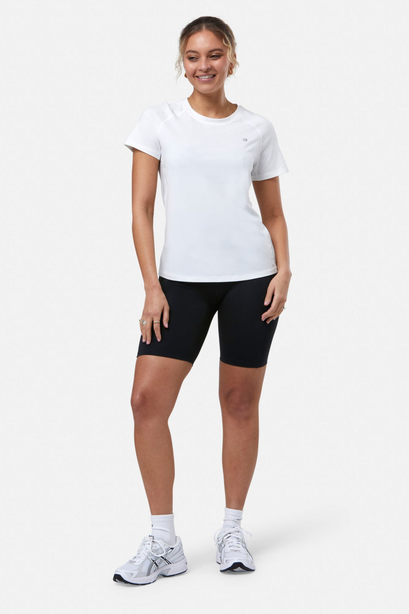 Woman wearing Gym+Coffee Relentless Tee in Ultra White by Gym+Coffee, shop the vendor at Dotique for this breathable performance tee