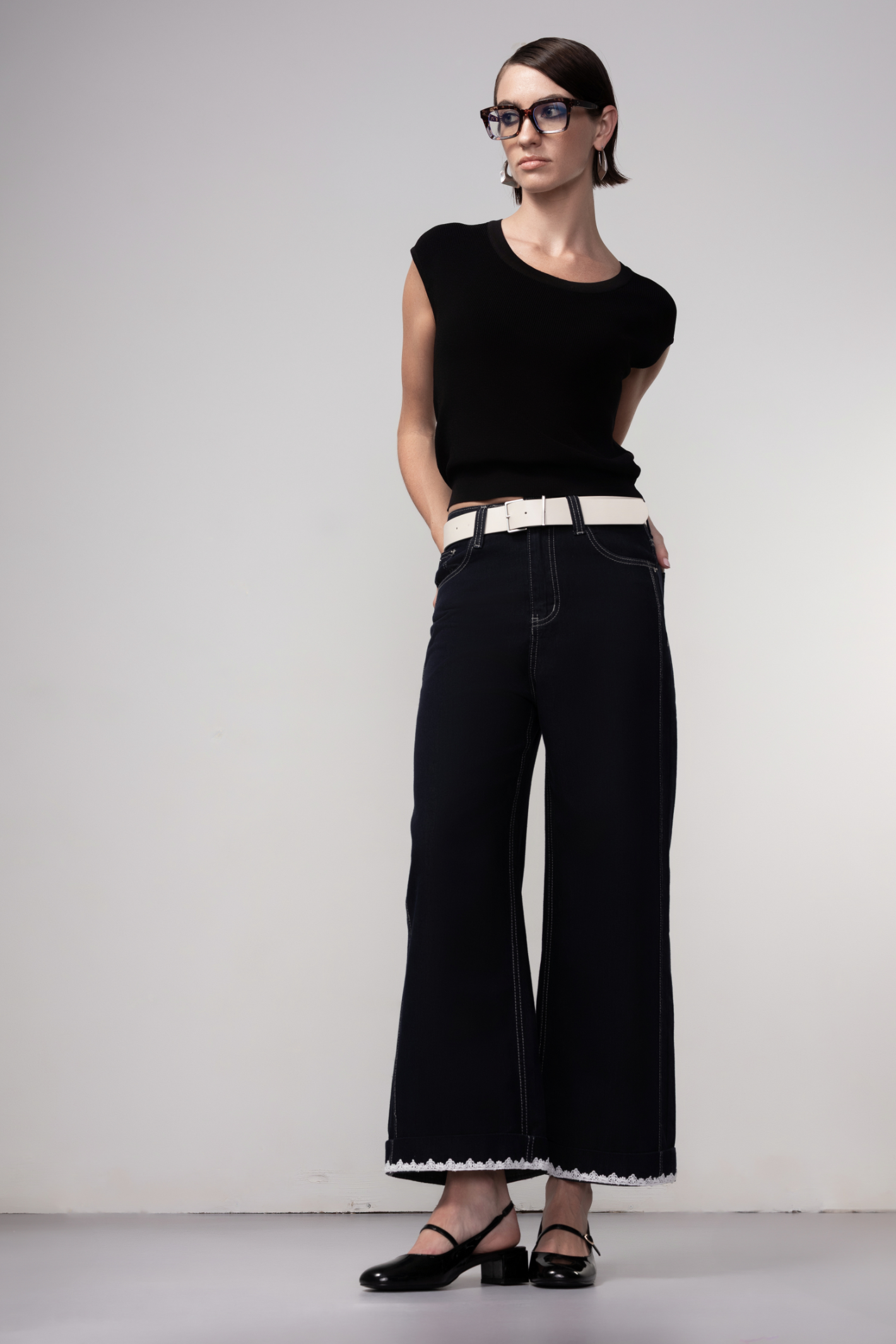 Haako dark blue wide leg jeans with contrast stitching and cream belt, styled for a modern minimalist look