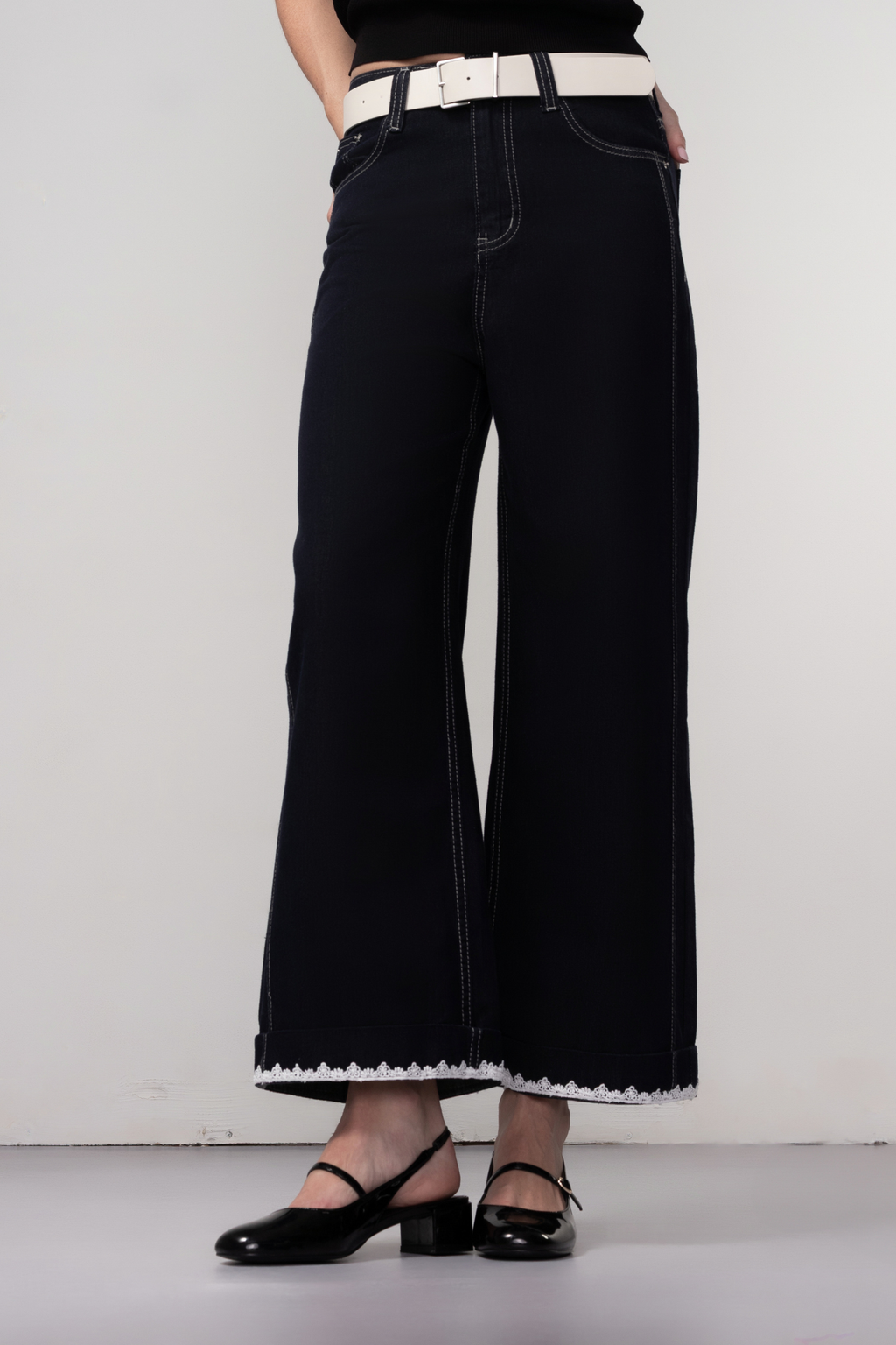 Haako dark blue wide leg jeans with contrast stitching and cream belt, styled for a modern minimalist look