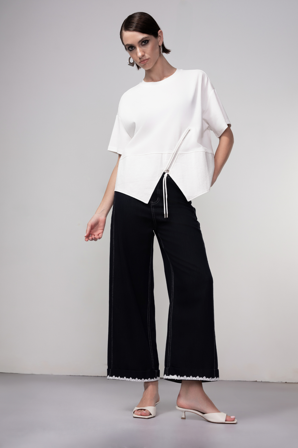 Haako dark blue wide leg jeans with contrast stitching and cream belt, styled for a modern minimalist look