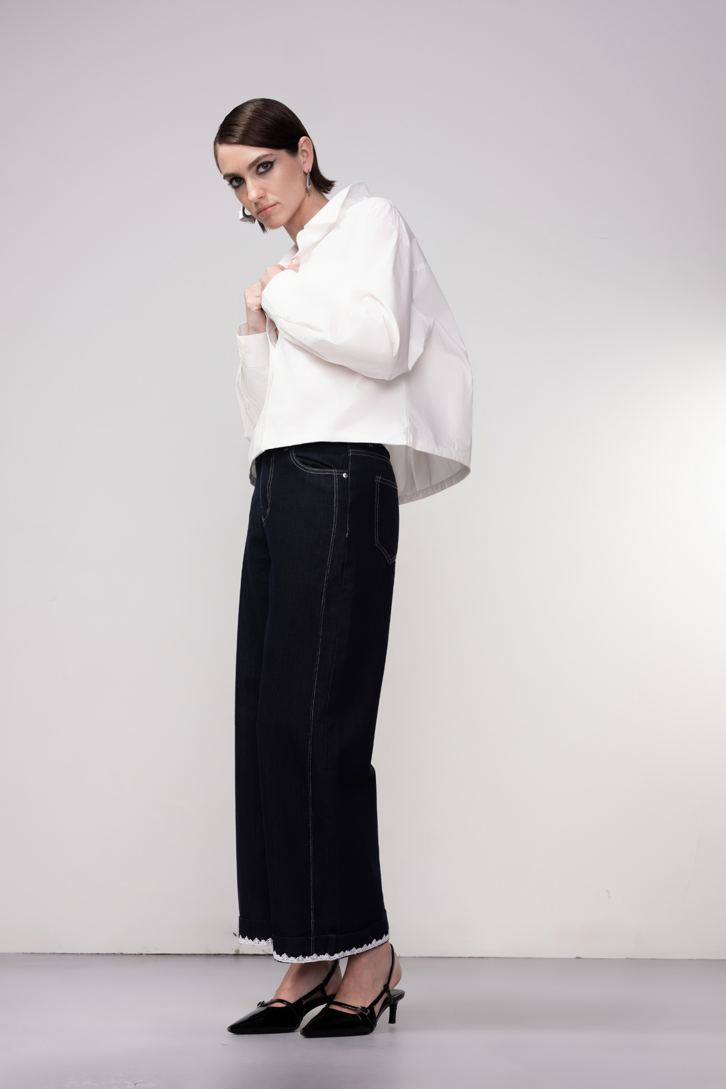 Haako dark blue wide leg jeans with contrast stitching and cream belt, styled for a modern minimalist look