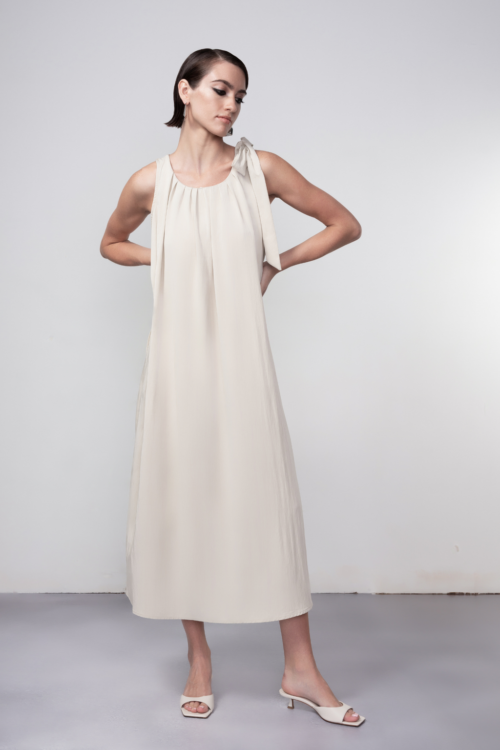 Haako stone sleeveless midi dress with tie shoulder detail styled in a minimalist look at Dotique