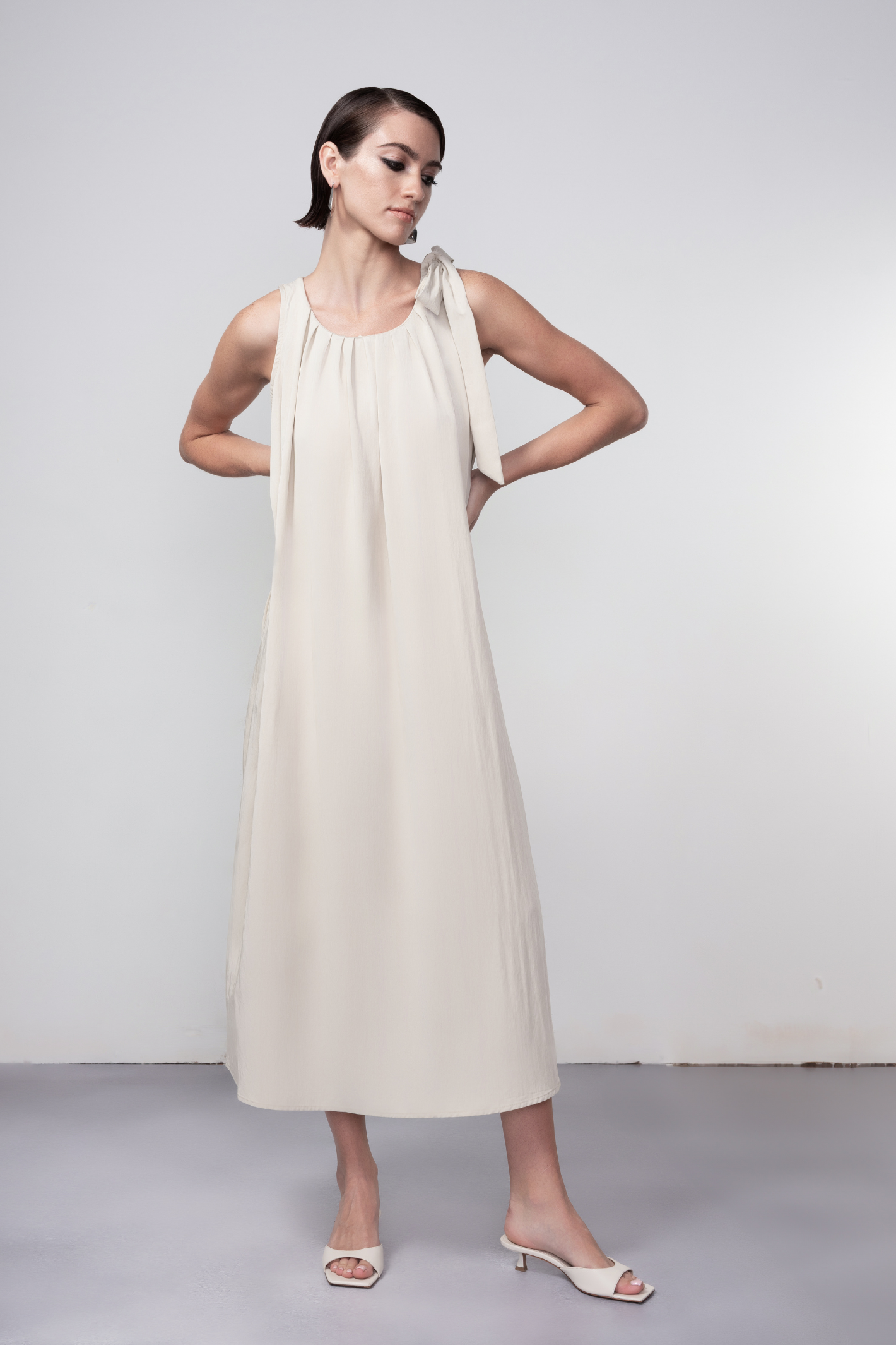Haako stone sleeveless midi dress with tie shoulder detail styled in a minimalist look at Dotique