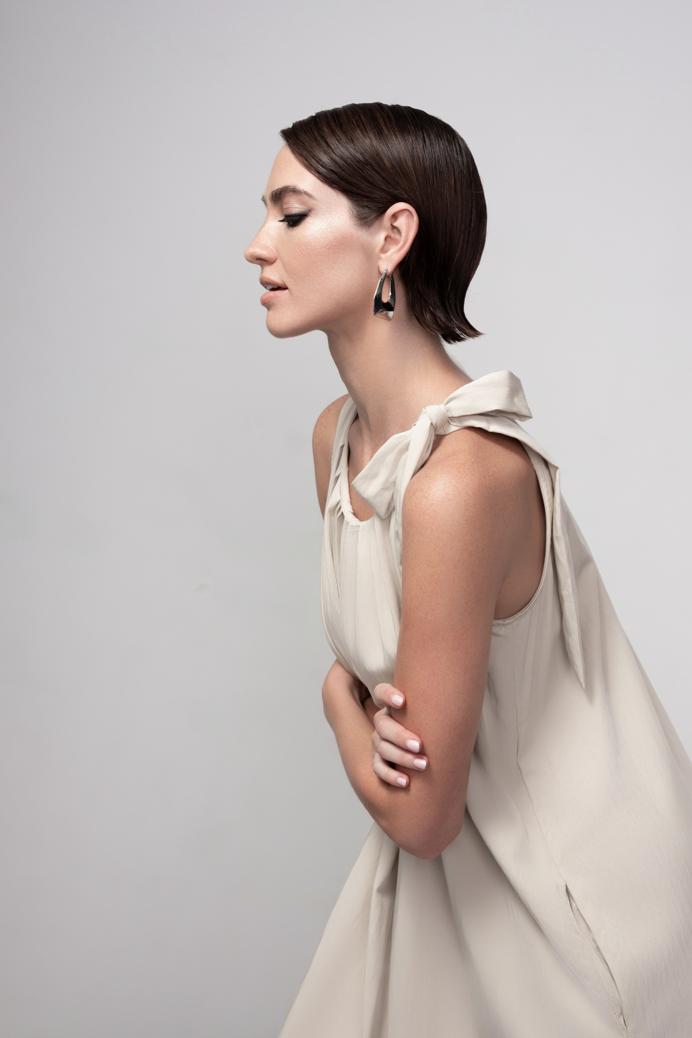 Haako stone sleeveless midi dress with tie shoulder detail styled in a minimalist look at Dotique