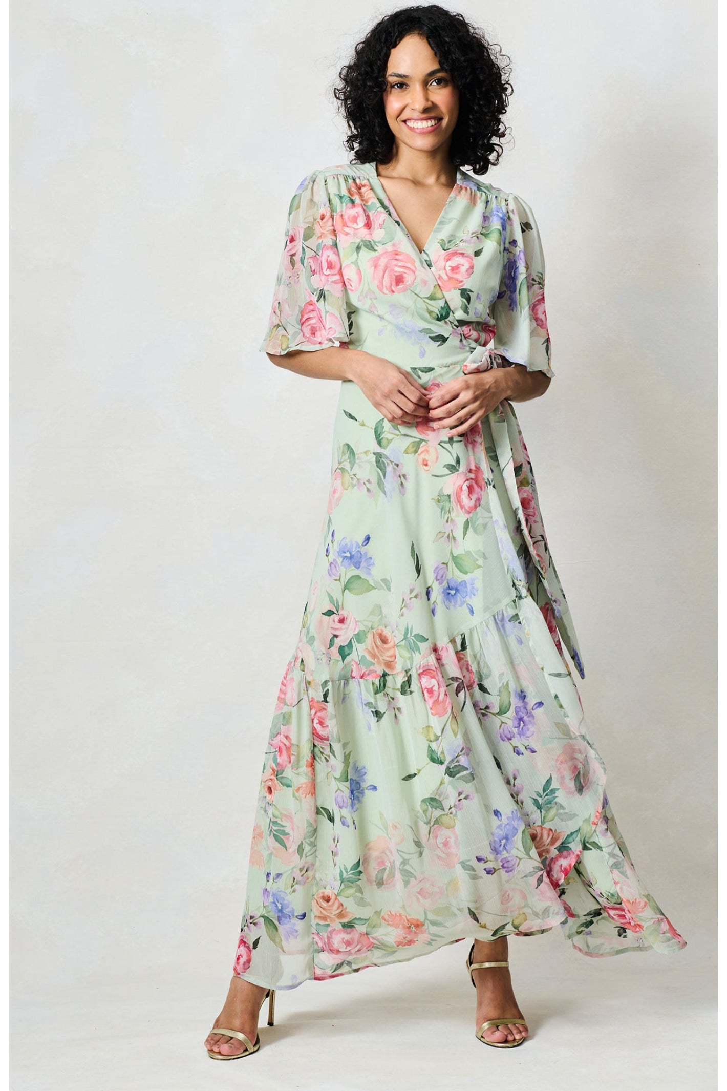 Woman wearing Hope & Ivy The Emi Flutter Sleeve Floral Wrap Maxi Dress Green by Hope and Ivy shop at Dotique