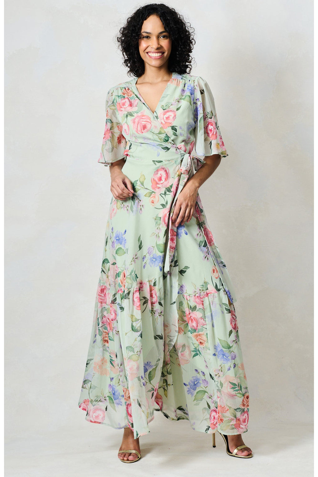 Woman wearing Hope & Ivy The Emi Flutter Sleeve Floral Wrap Maxi Dress Green by Hope and Ivy Shop Hope and Ivy at Dotique