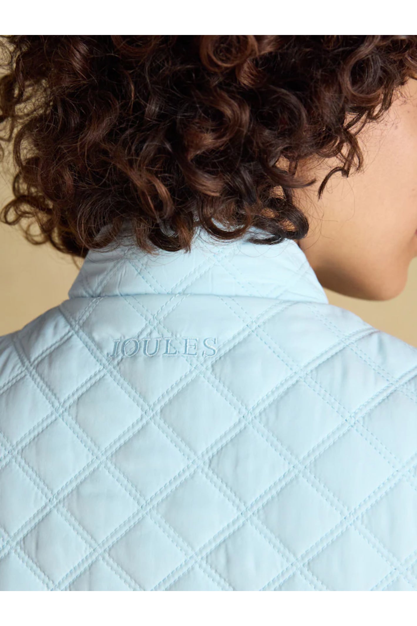 Close-up of quilted powder blue Joules F86654 Minx Quilted Gilet worn by model, shop Joules at Dotique.