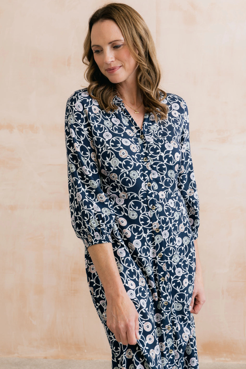 Model wearing Lily & Me LM26022 Leoni Dress Sea Holly Navy with button front and floral print by Lily & me. Shop Lily & me at Dotique.