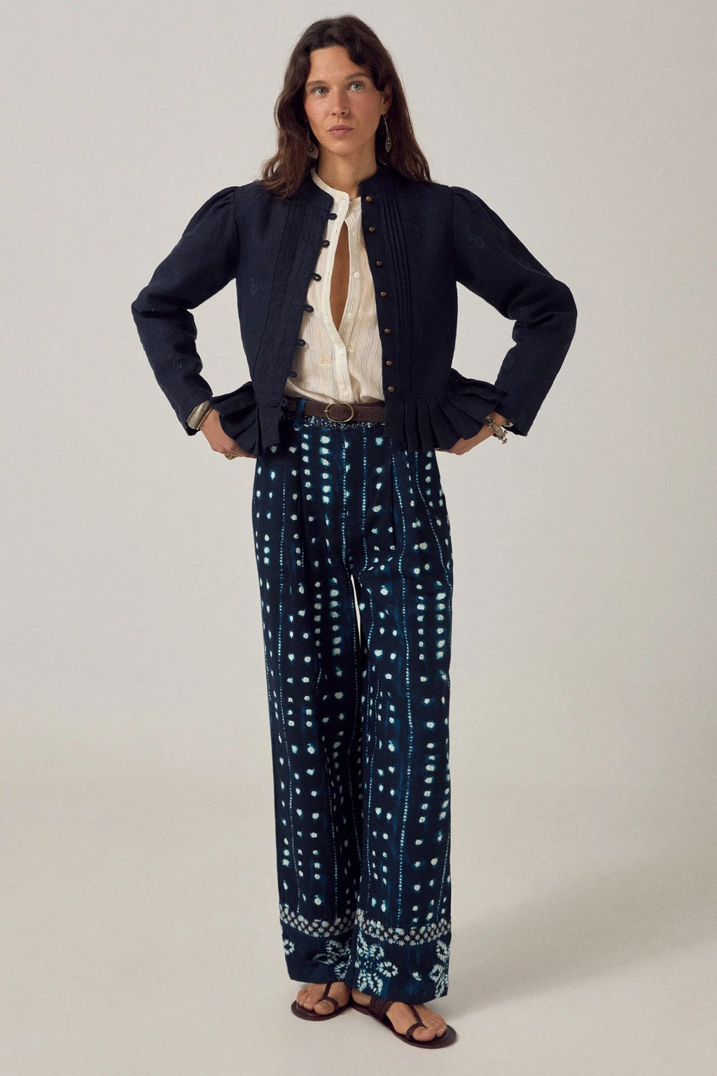 Model wearing Maison Hotel Caroline Blouse Off White paired with a dark jacket and patterned trousers, shop Maison Hotel at Dotique.