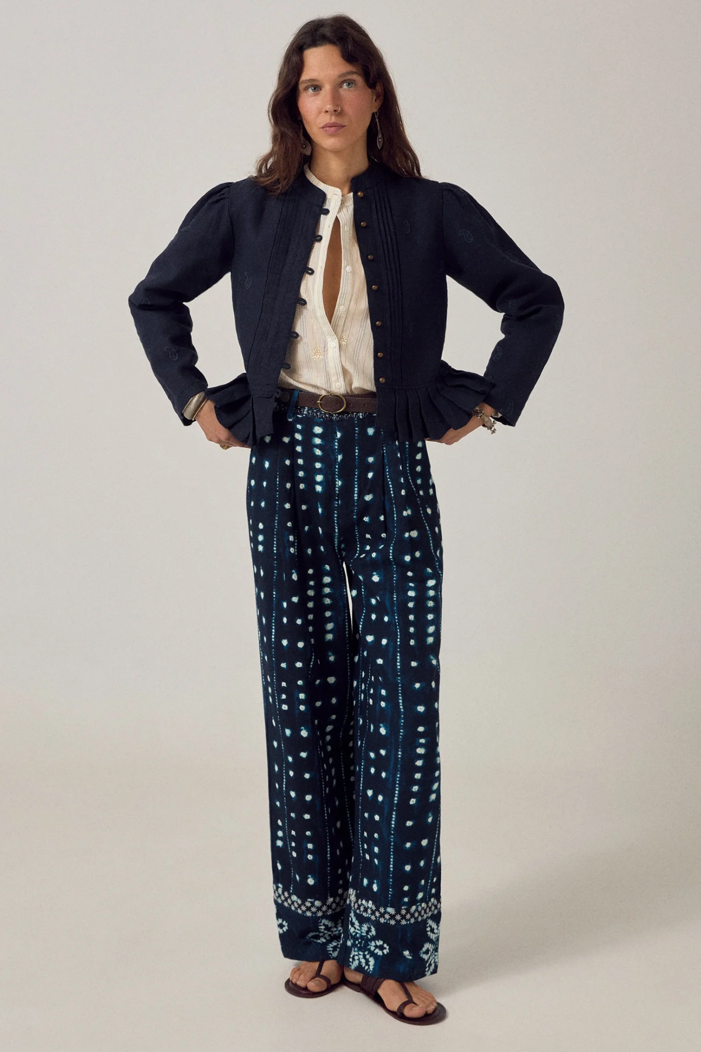 Model wearing Maison Hotel Caroline Blouse Off White paired with a dark jacket and patterned trousers, shop Maison Hotel at Dotique.
