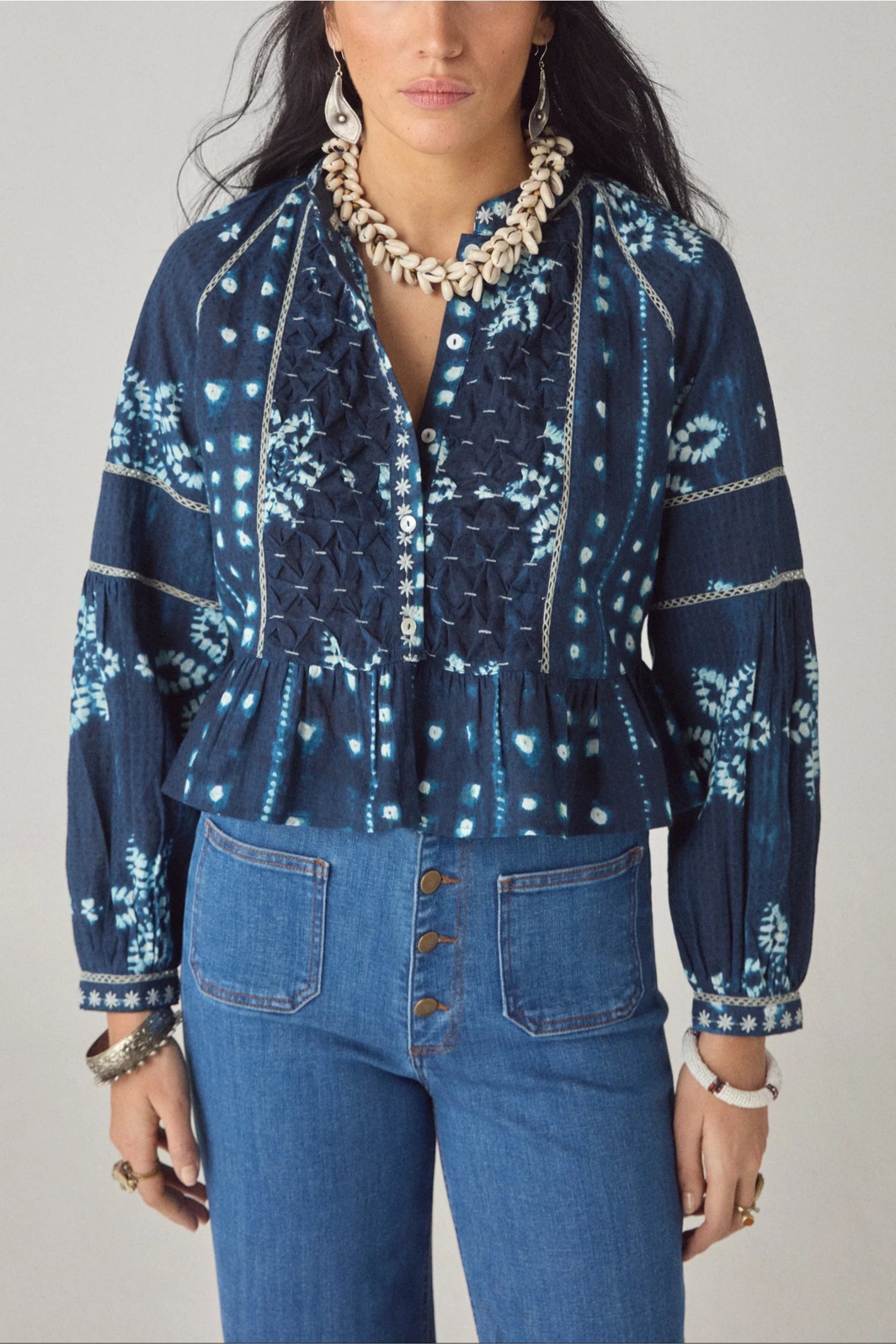 Woman wearing Maison Hotel Sora Blouse Shibori Dreams Ocean Ink in navy with shell necklace, shop Maison Hotel at Dotique.