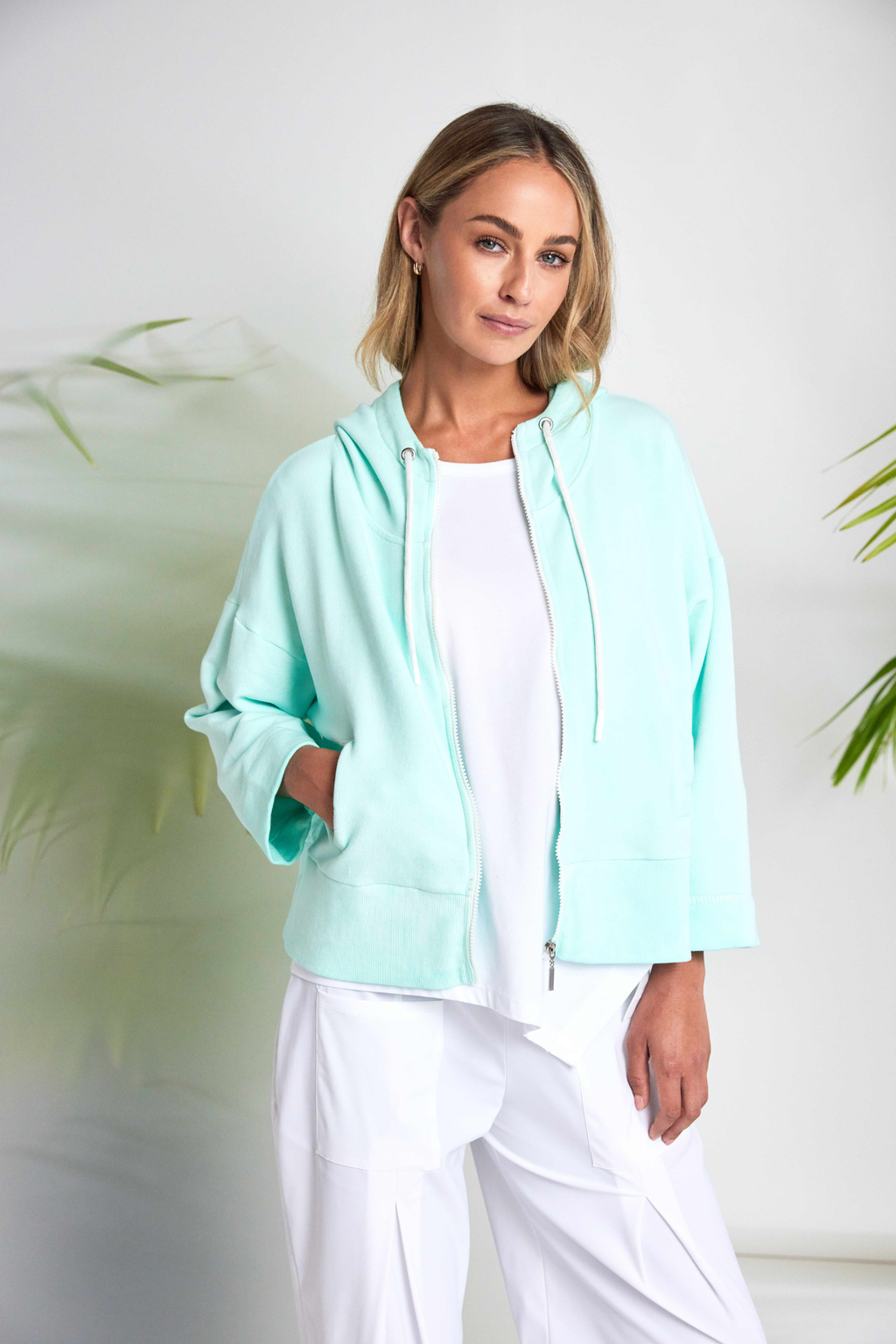 White Naya jersey top with a relaxed fit and cut-out hem detail. Soft, easy to wear and perfect for everyday. Shop at Dotique.