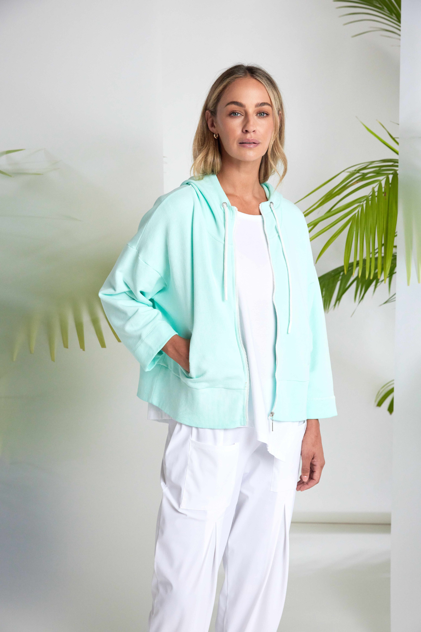 White Naya jersey top with a relaxed fit and cut-out hem detail. Soft, easy to wear and perfect for everyday. Shop at Dotique.