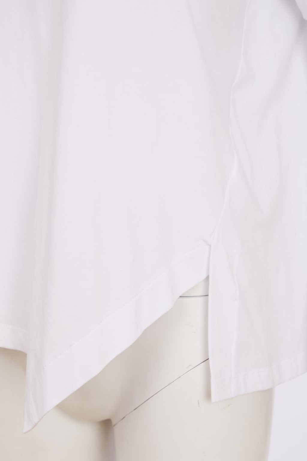 White Naya jersey top with a relaxed fit and cut-out hem detail. Soft, easy to wear and perfect for everyday. Shop at Dotique.