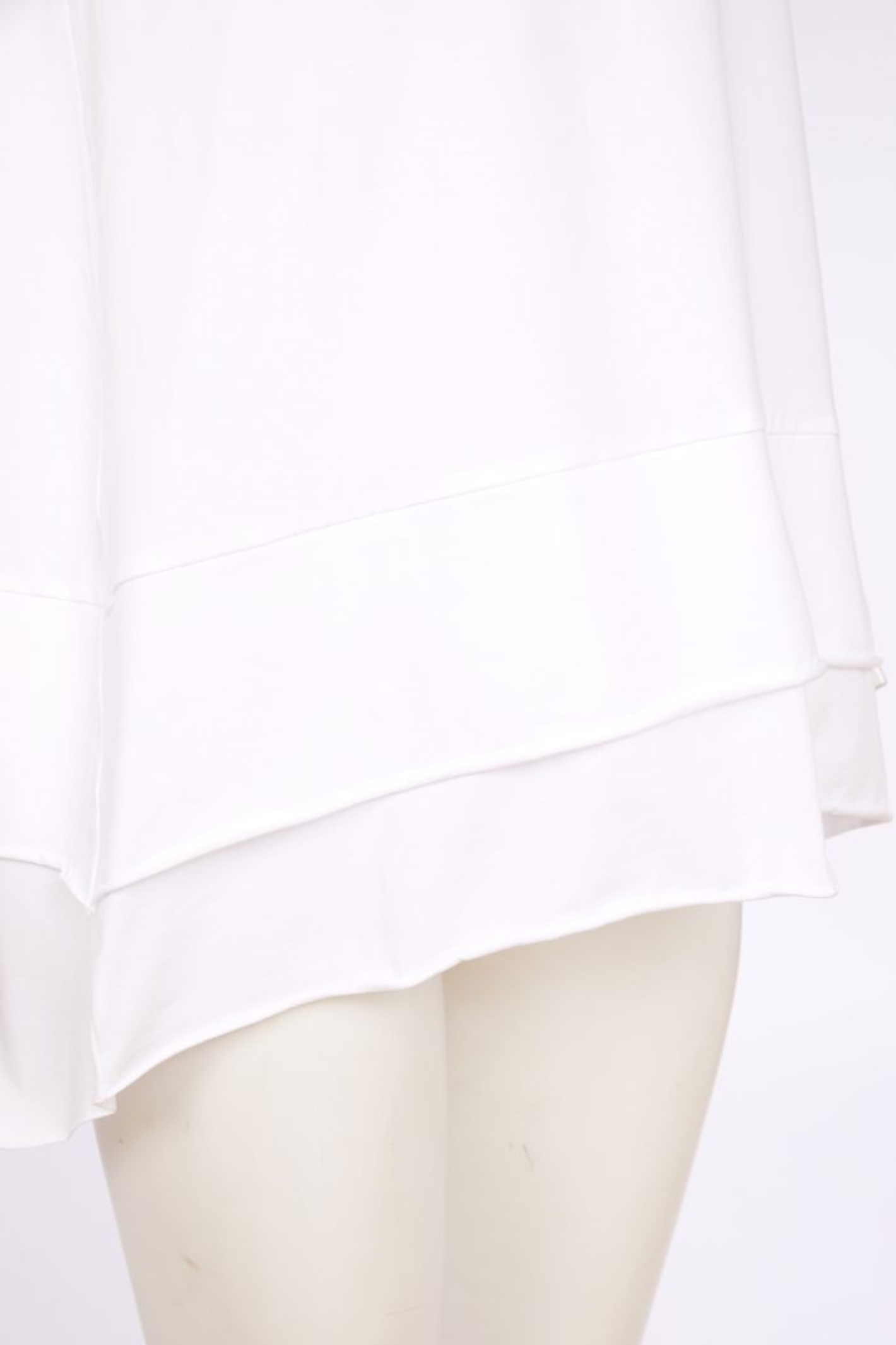 White Naya cami top with wide straps, layered raw hem and back vent. Soft, flattering and perfect for layering. Shop at Dotique.