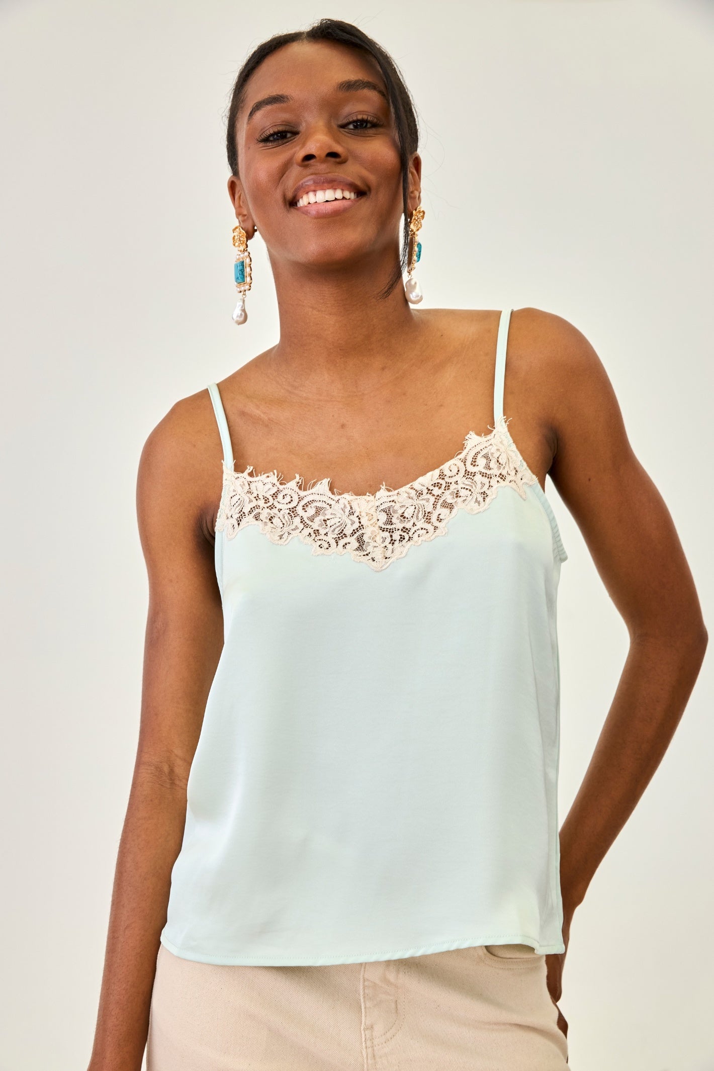 Smiling woman wearing NKN Nekane Marci Aqua Strppy Top with Lace Neckline from NKN Nekane, shop at Dotique.