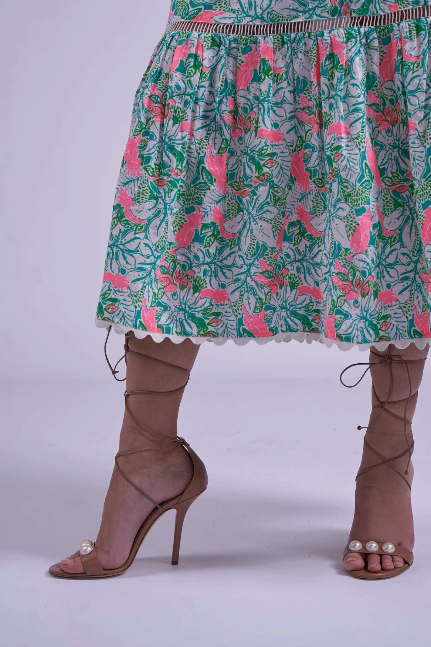 Partial view of New Day Originals Misha Pink Parrot dress with floral print, paired with nude heels by New Day Originals, shop at Dotique