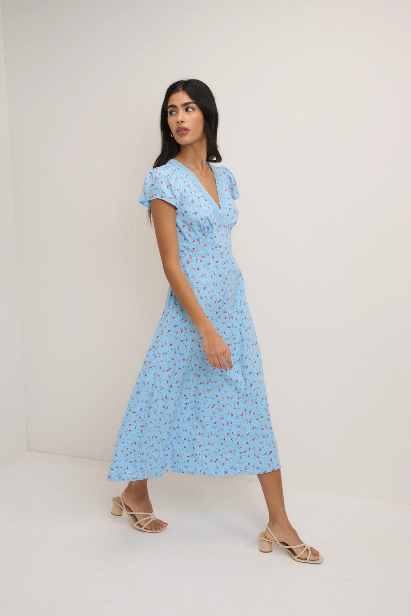 Woman wearing Nobody’s Child Kacey Blue Ditsy Floral Midi Dress by Nobody’s Child, shop the brand exclusively at Dotique.