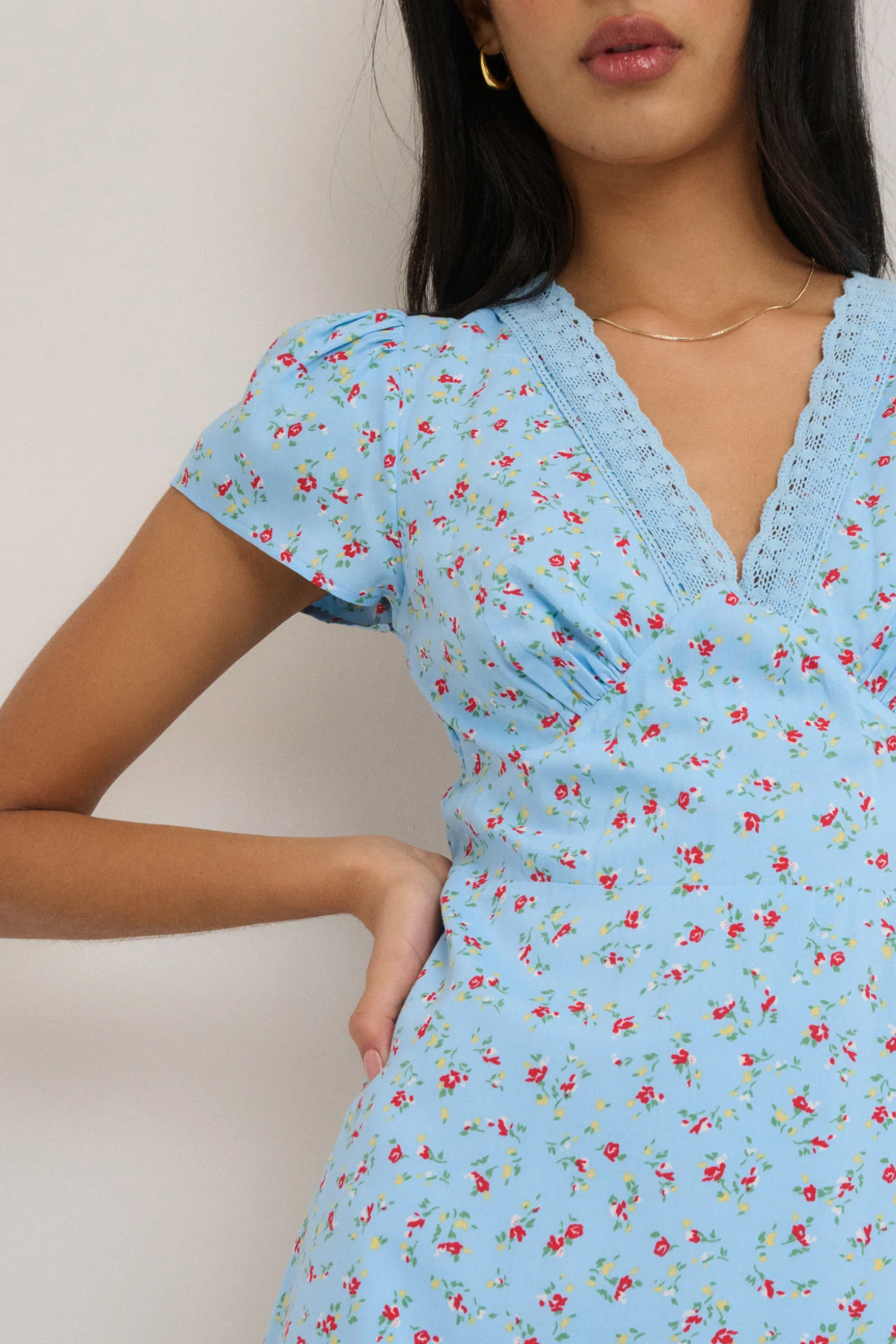 Close-up of model wearing Nobody’s Child Kacey Blue Ditsy Floral Midi Dress by Nobody’s Child, shop Nobody’s Child at Dotique.