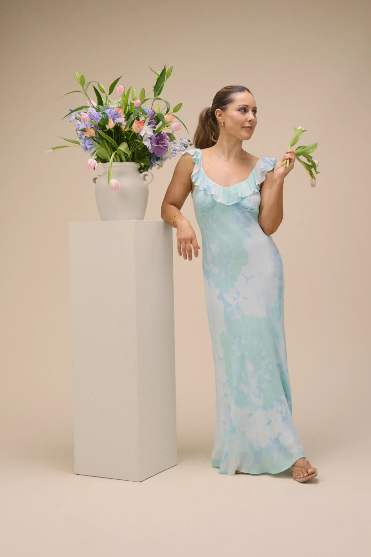 Elegant model wearing Nobody's Child Blue Floral Chiffon Logan Midi Dress by Nobody’s Child holding flowers, shop at Dotique.