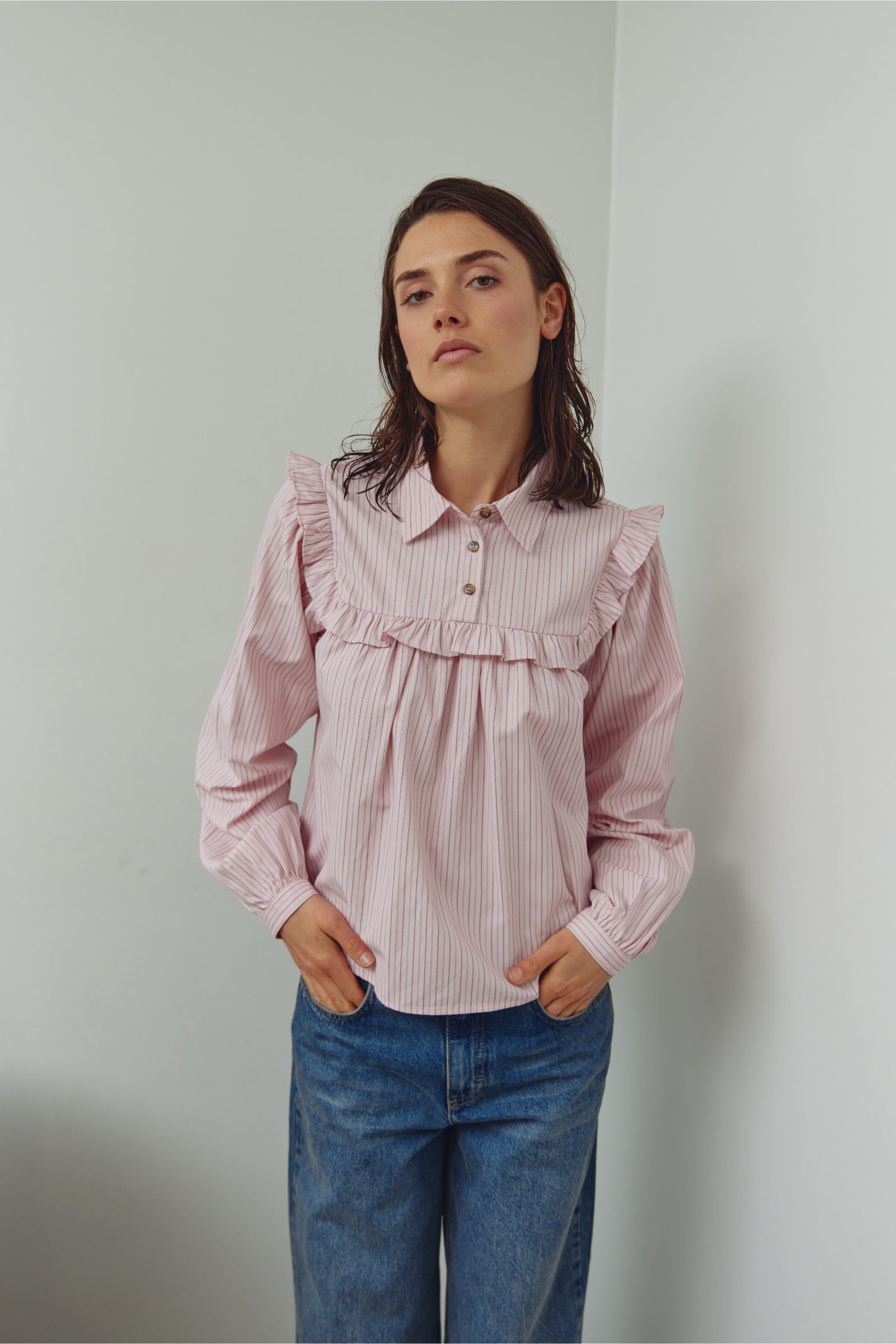 Model wearing Noella 15360001 N-Mikayla Blouse Donnie Blush Stripe by noella shop noella at Dotique in soft pink with ruffle details