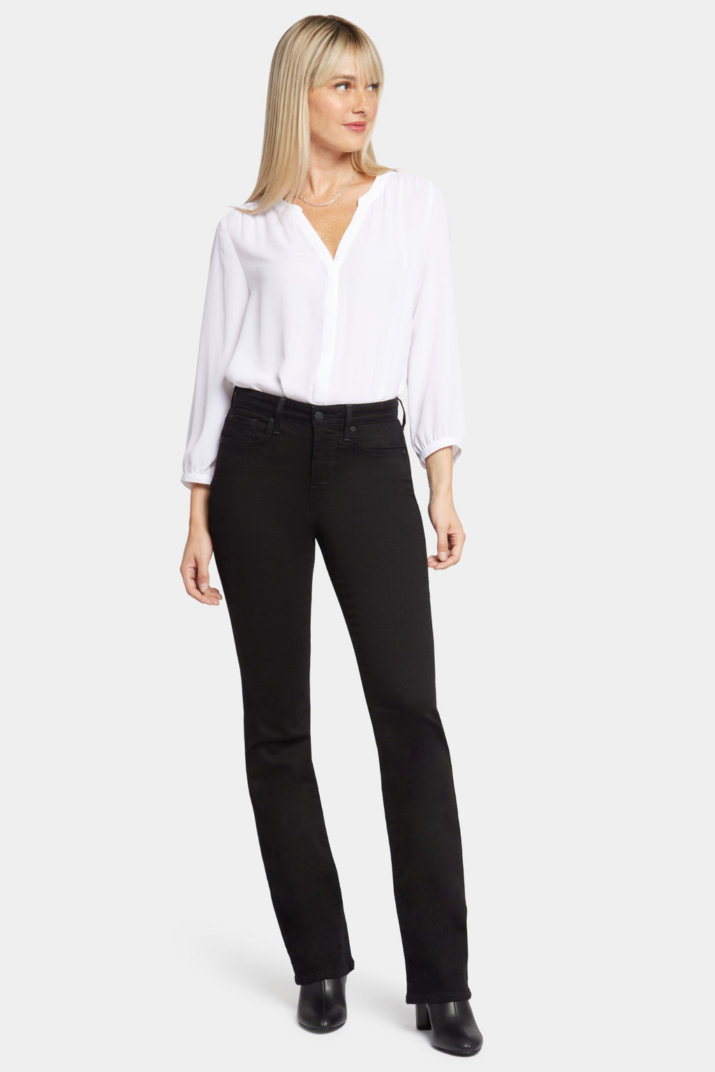 Woman wearing NYDJ Barbara Bootcut Black Jeans 30” paired with white blouse, shop NYDJ at Dotique for stylish denim.
