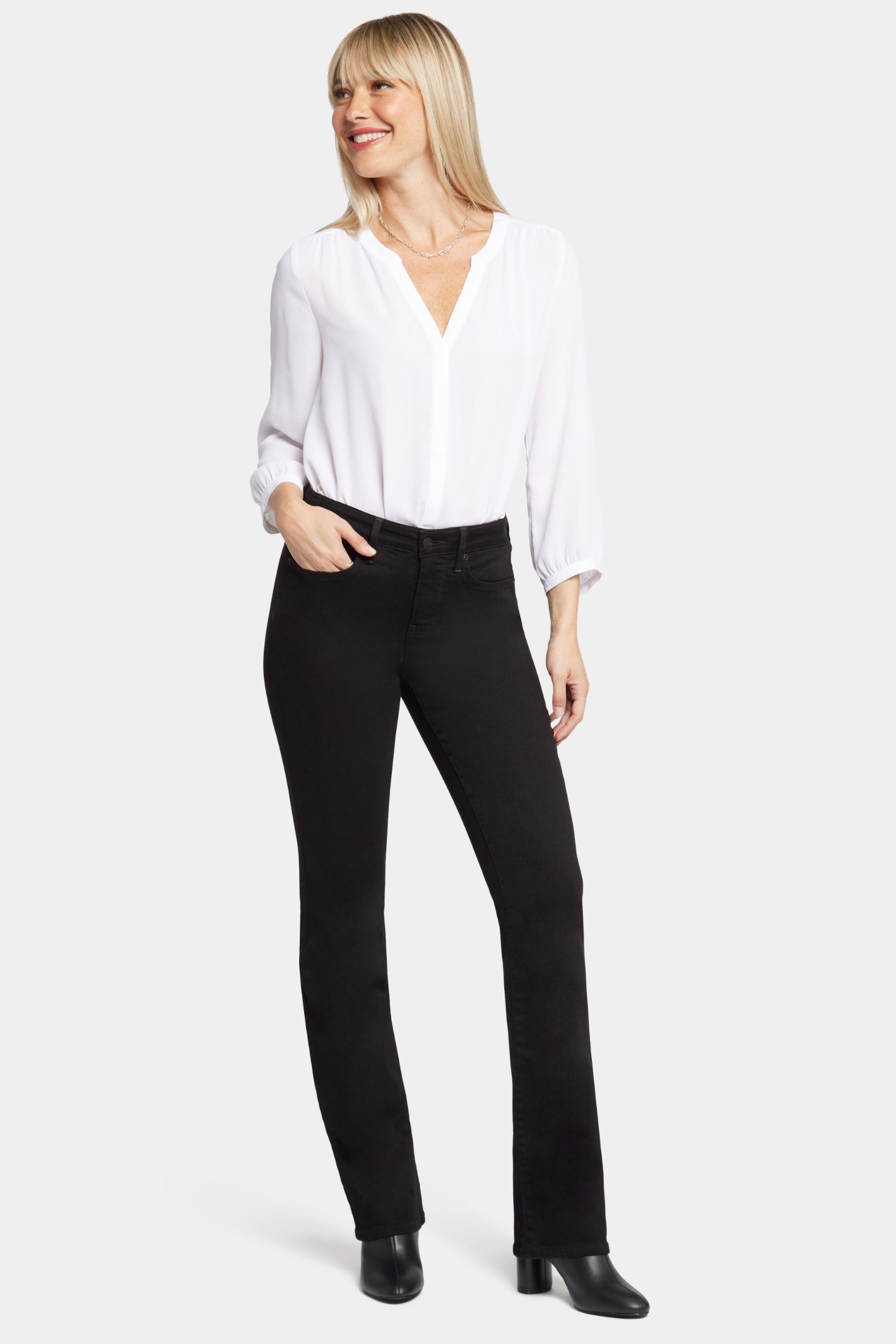 Woman wearing NYDJ Barbara Bootcut Black Jeans 30” styled with white blouse, shop the NYDJ collection at Dotique