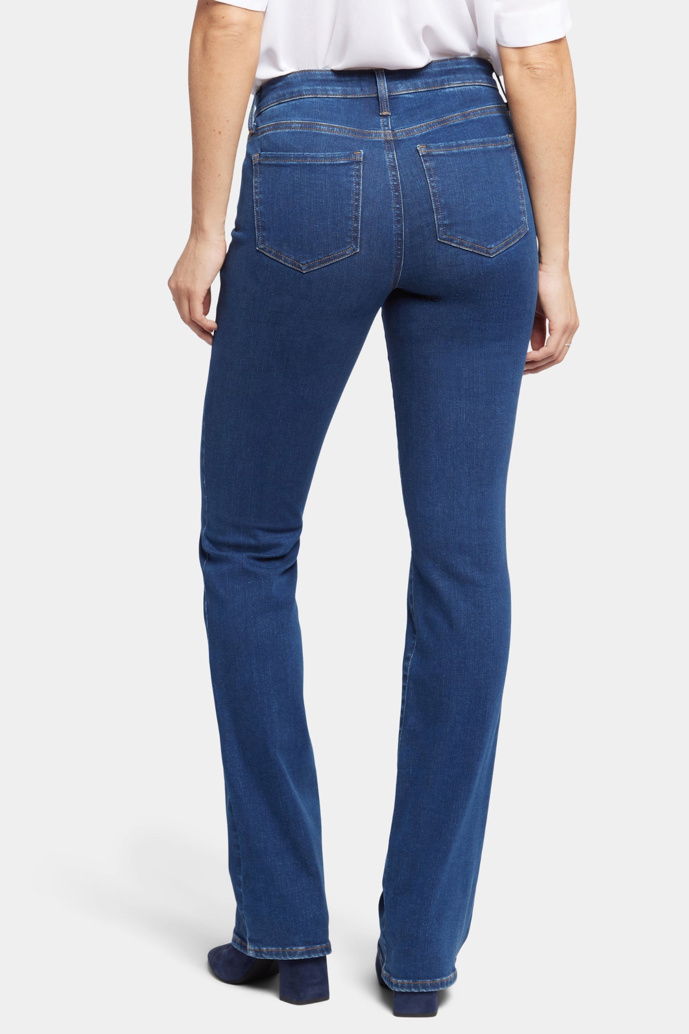 Woman wearing NYDJ Barbara Bootcut Quinn Jeans 30” in blue denim, shop NYDJ at Dotique for stylish bootcut jeans.