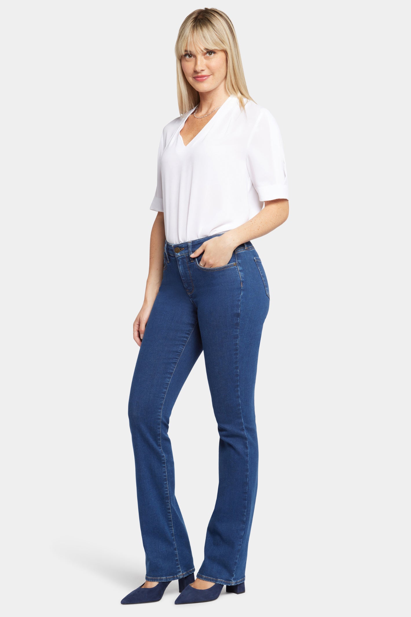 Woman wearing NYDJ Barbara Bootcut Quinn Jeans 30” paired with white blouse, shop NYDJ at Dotique for stylish denim.