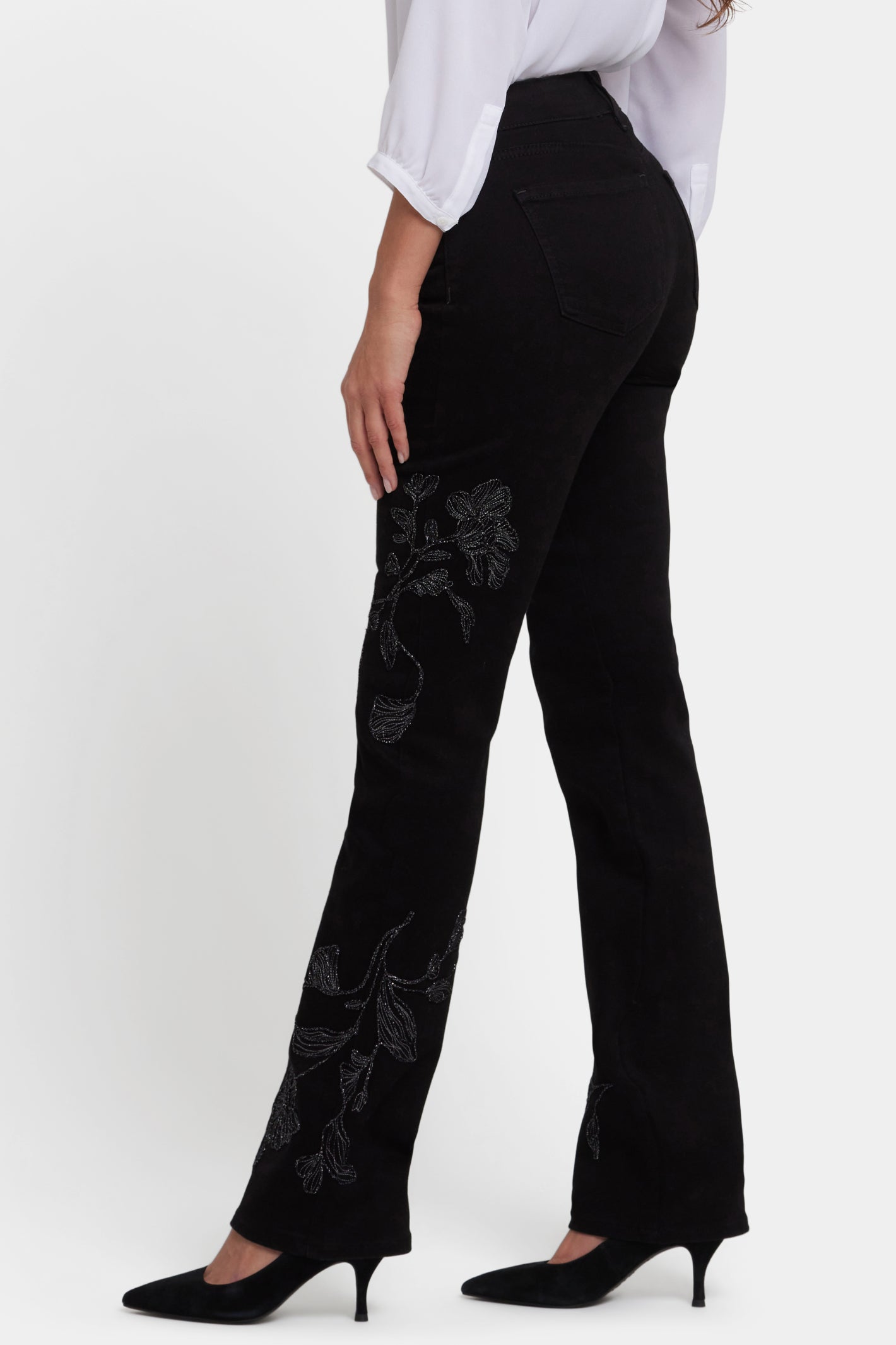 Woman wearing NYDJ Marilyn Straight Black Jeans 30” with floral print, shop NYDJ at Dotique for stylish denim options.