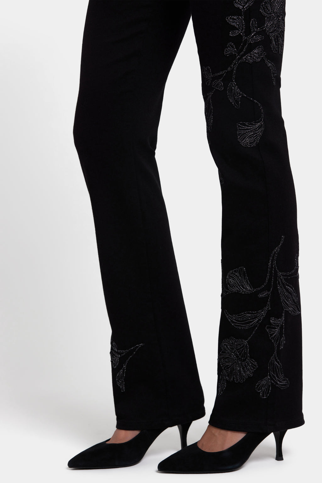 Close-up of legs wearing NYDJ Marilyn Straight Black Jeans 32” with floral embroidery, shop NYDJ at Dotique.