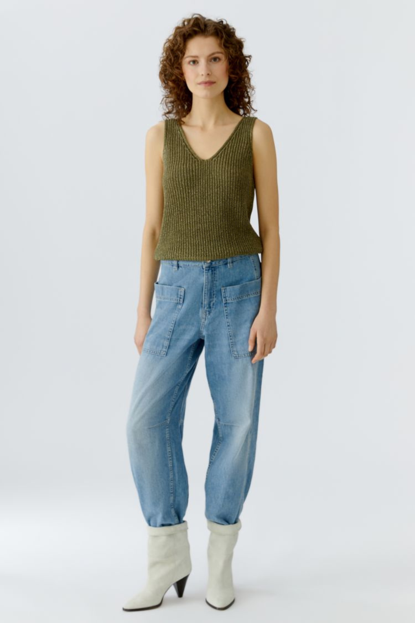 Sleeveless knitted top by Oui in Green Garden. Lightweight with a soft metallic shimmer and flattering V-neck. Easy to layer or wear alone. Shop at Dotique.