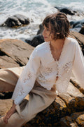 Woman wearing Part Two 30310454 AnamariaPW Whisper White Blouse by Part Two seated on rocks by water Shop Part Two at Dotique