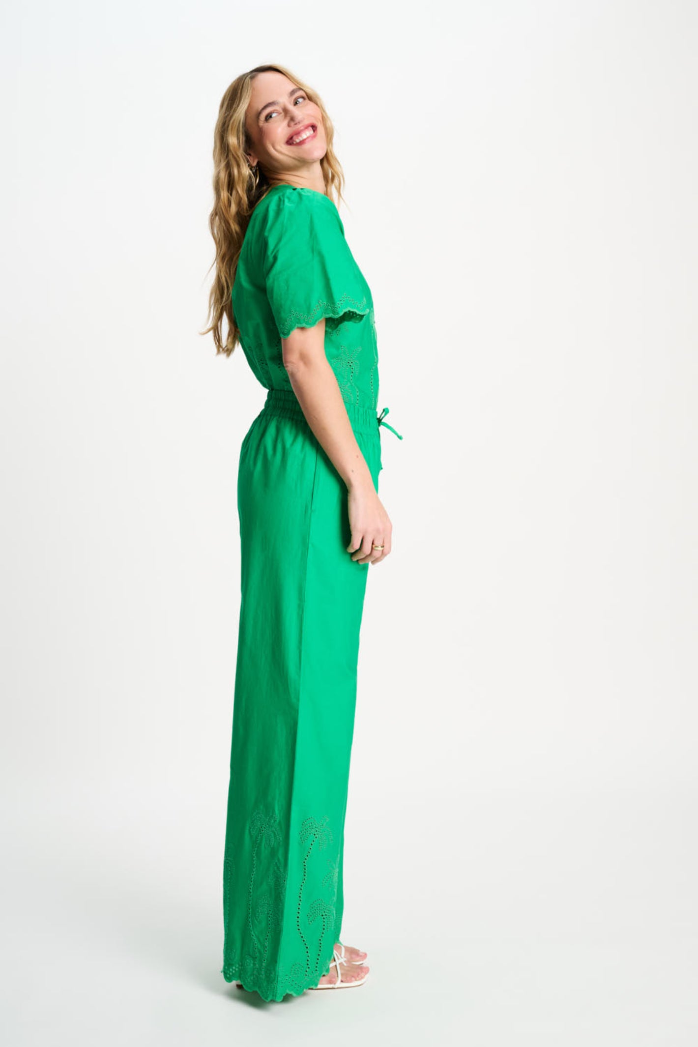 Side profile of woman in Pom Amsterdam SP9565 Broderie Anglaise Palm Green Organic Cotton Trousers by Pom Amsterdam shop Dotique