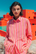Model wearing Vilagallo 33314 Pink Coral Stripe Shirt by Vilagallo with orange buildings in background Shop Vilagallo at Dotique