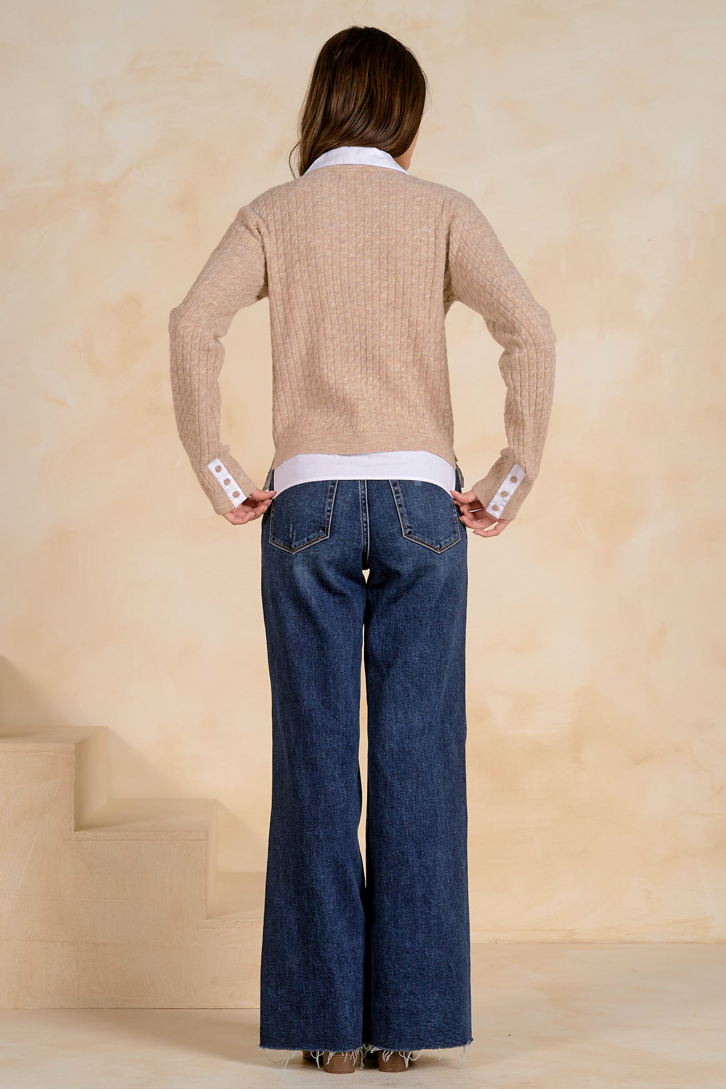 Model seen from behind wearing the Elan SWB11714 Collared Cardigan Tan/White by Elan, styled with wide-leg jeans, shop Elan at Dotique.