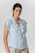 Model wearing Elisa Cavaletti Assisi Blue Ruffle Front Blouse EJP261069400 in soft blue with ruffle detailing, by Elisa Cavaletti, shop Elisa Cavaletti at Dotique.