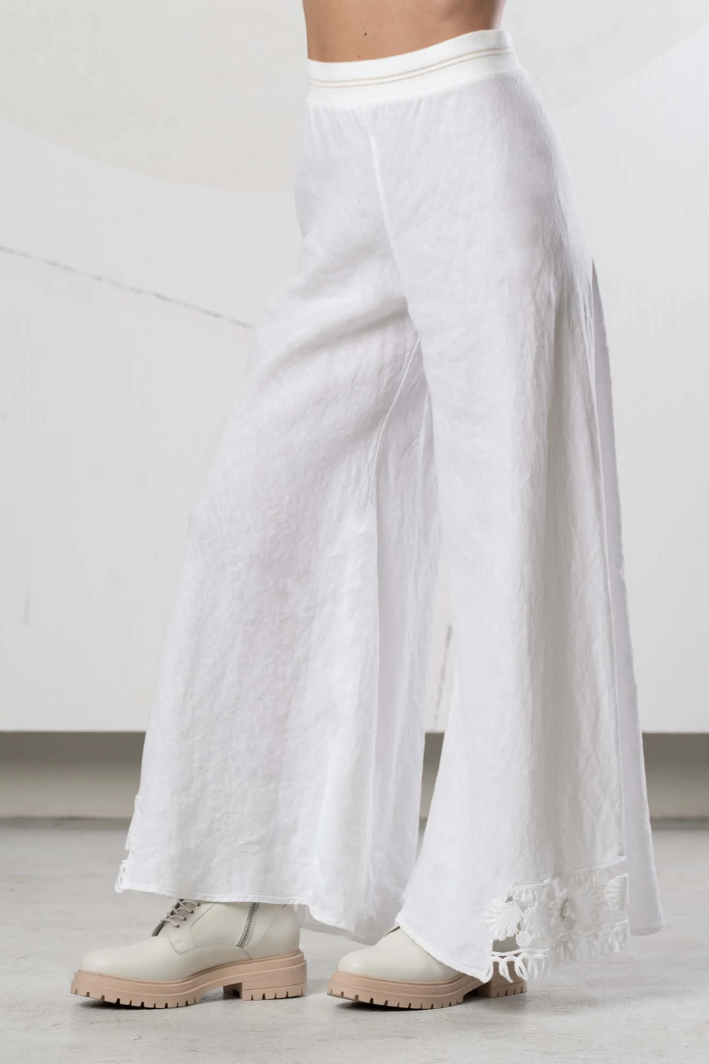 Side view of model wearing Elisa Cavaletti Bianco Linen Wide Leg Trousers EAP266098201 01001 in white linen with floral hem detail by Elisa Cavaletti, shop Elisa Cavaletti at Dotique.