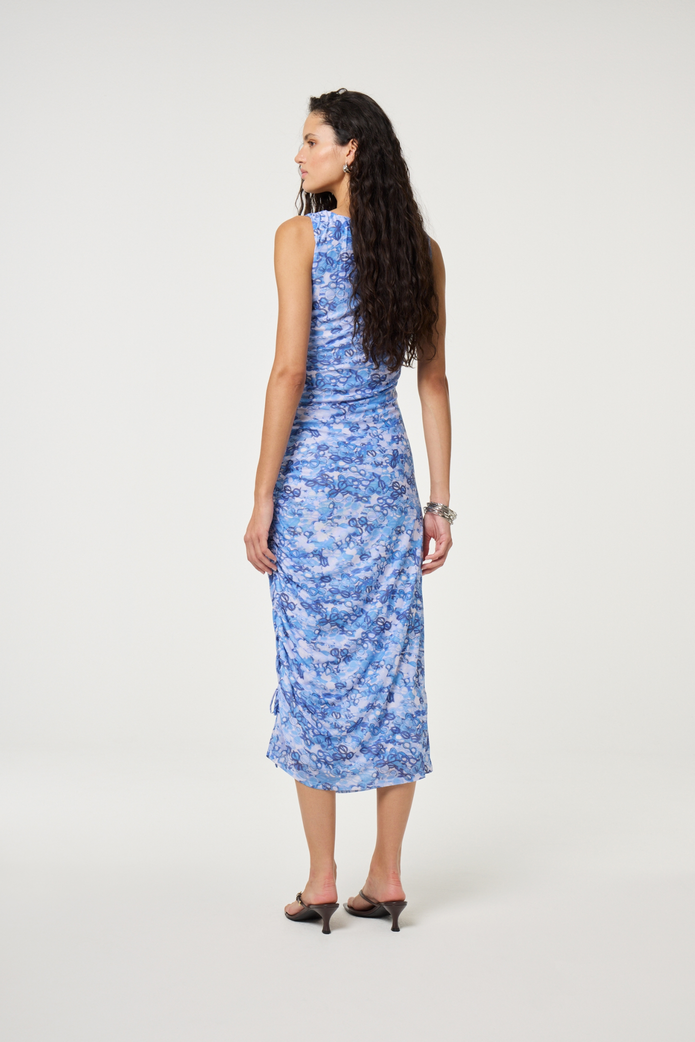 Model seen from behind wearing Fabienne Chapot Zina Dress Sea of Sunglasses Blue featuring a blue printed design, shop Fabienne Chapot at Dotique.
