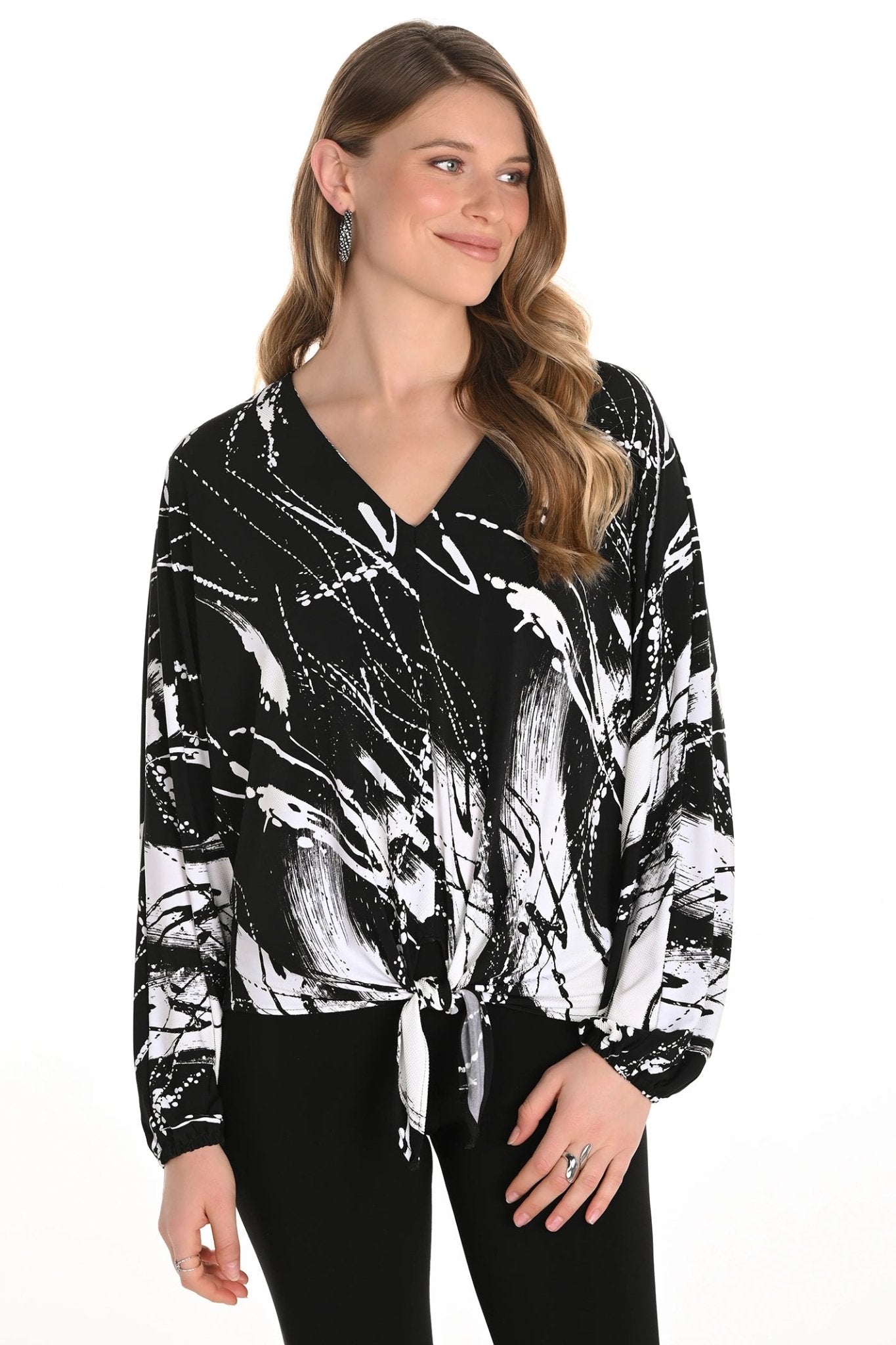 Woman wearing a black and white abstract patterned blouse on a white background