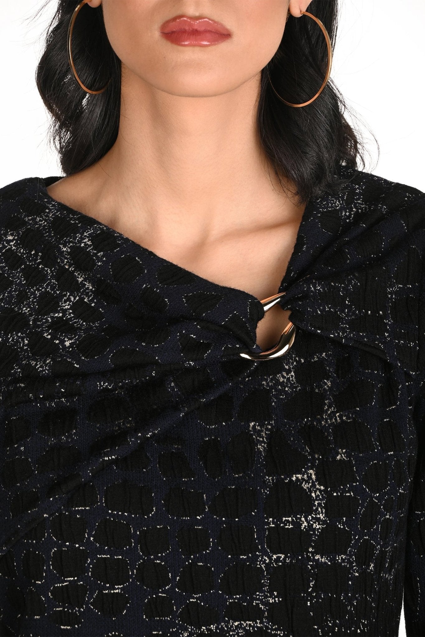 Close-up of a person wearing a dark blue textured top with a collar.