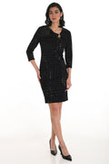 Woman wearing a black patterned dress on a white background