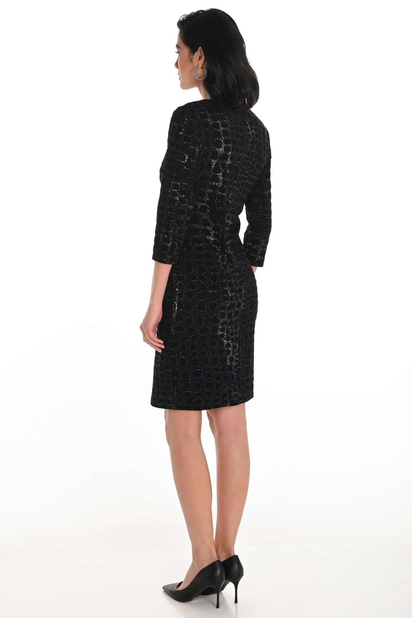 Woman wearing a black patterned dress on a white background