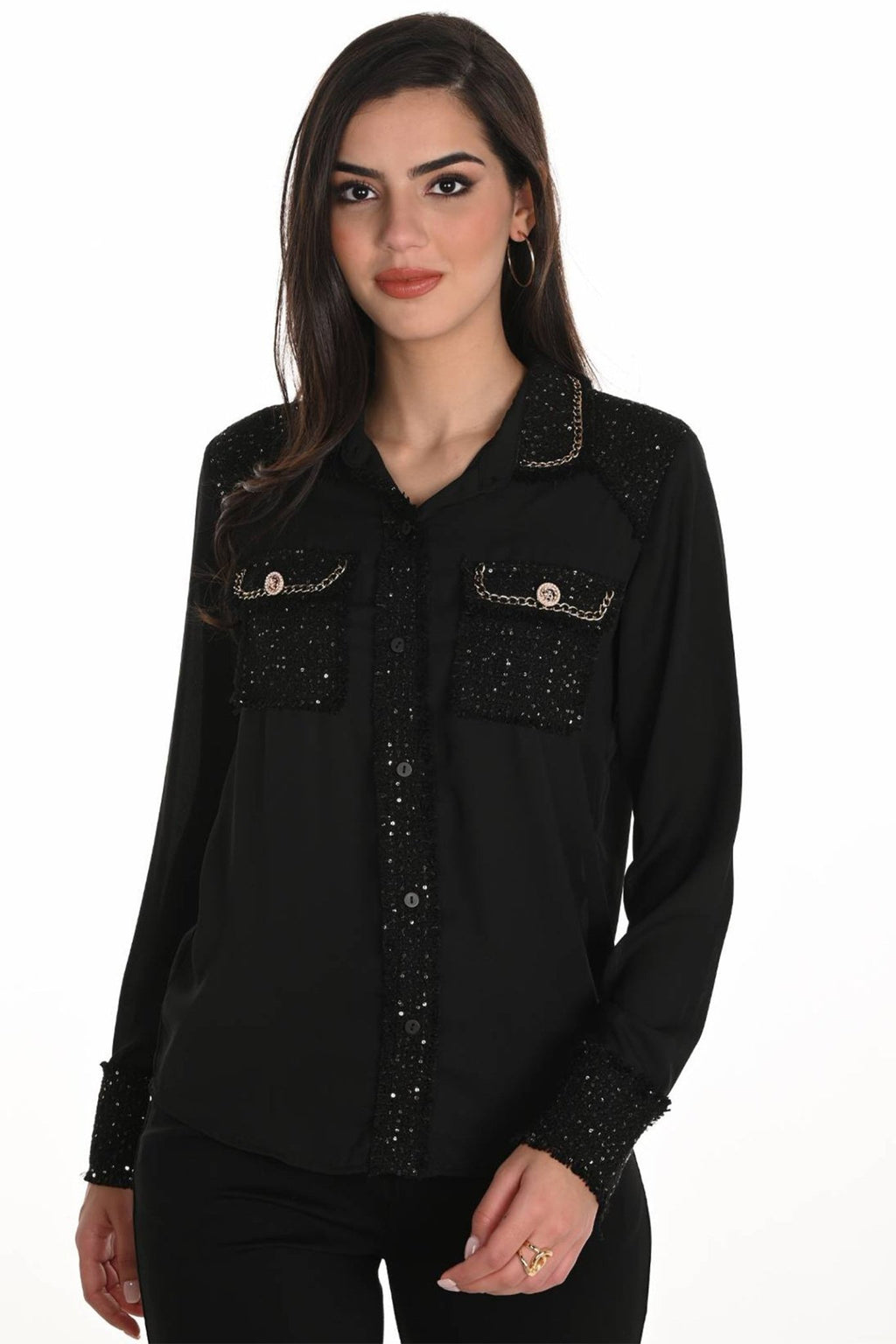 Woman wearing a black embellished shirt on a white background
