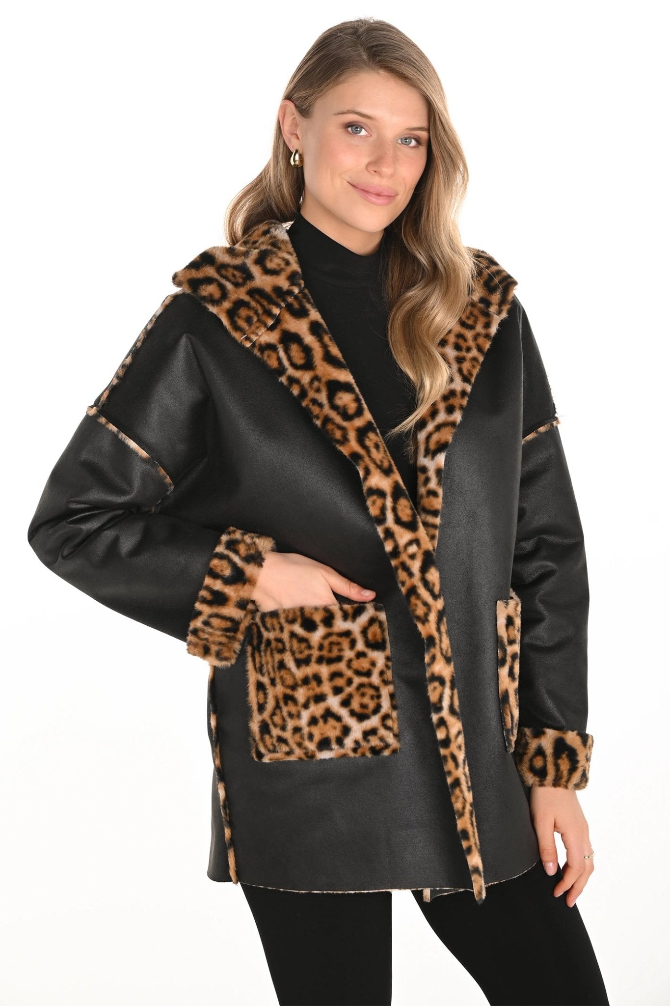 Woman wearing a black coat with leopard print trim on a white background